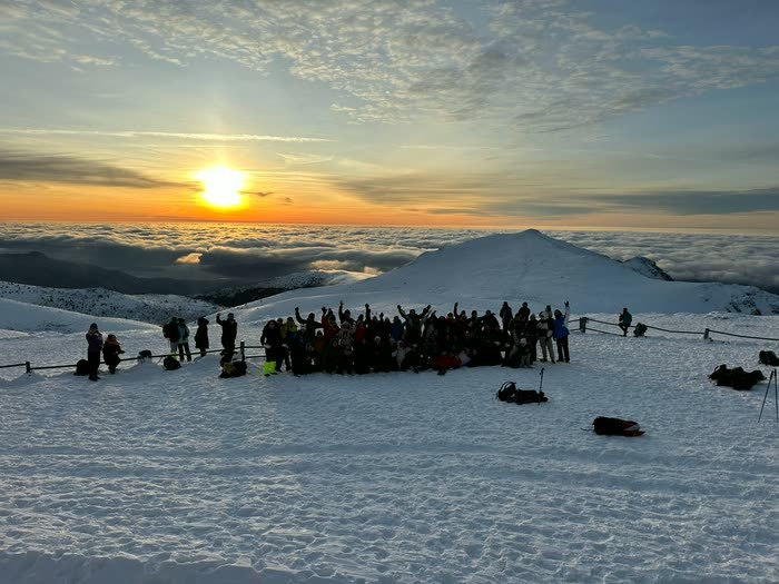 El sol saliendo sobre un mar de nubes, con todo el grupo mirando
