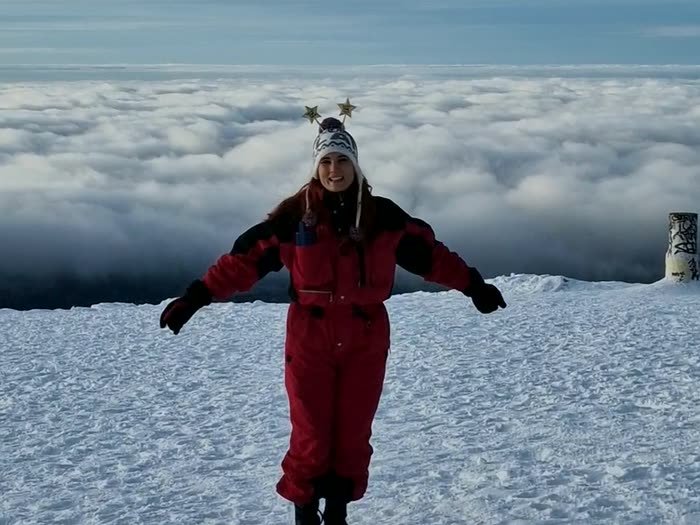 Con los brazos abiertos en la nieve, por encima de las nubes