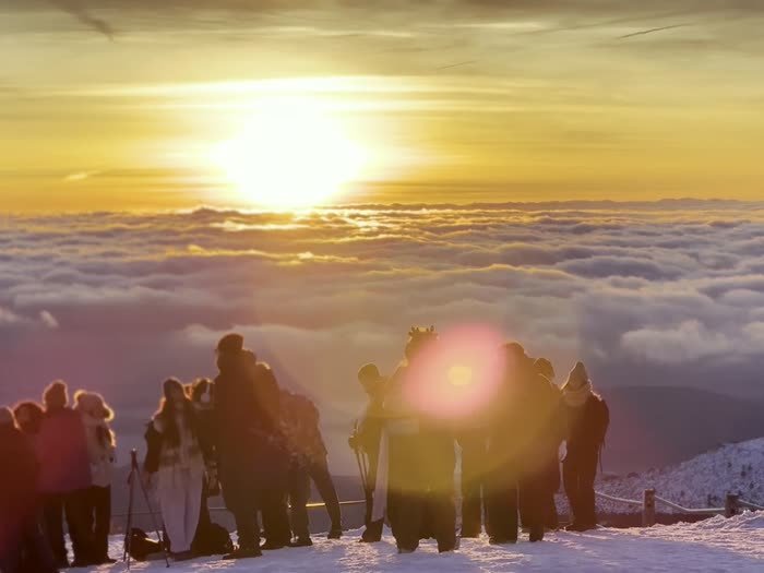 El sol saliendo sobre el mar de nubes, con el grupo a contraluz