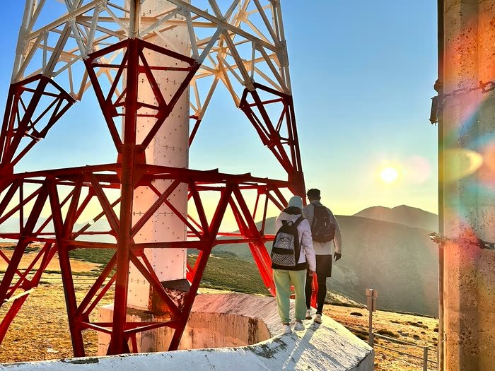 La antena roja y blanca de la cima con el sol bajando