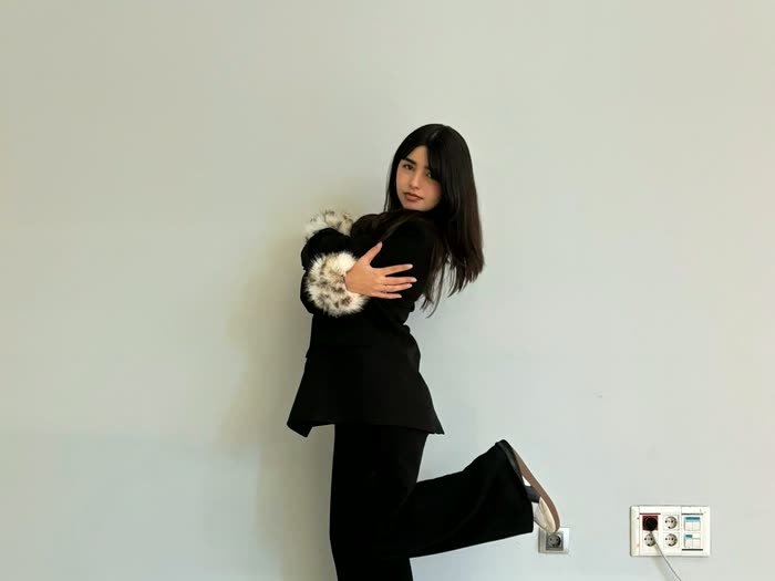 Una chica posando contra la pared para que el grupo la dibuje