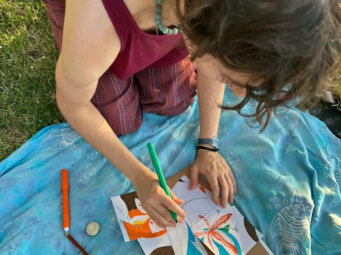 Una chica pintando concentrada sobre la manta