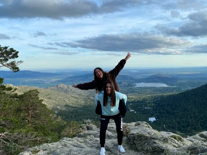 Dos en lo alto de una roca con los brazos al aire