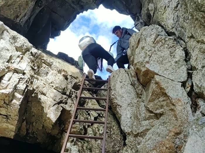 Subiendo una escalera de hierro entre las rocas