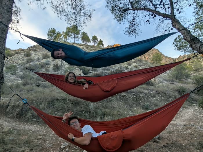 Hamacas colgadas unas encima de otras entre los árboles