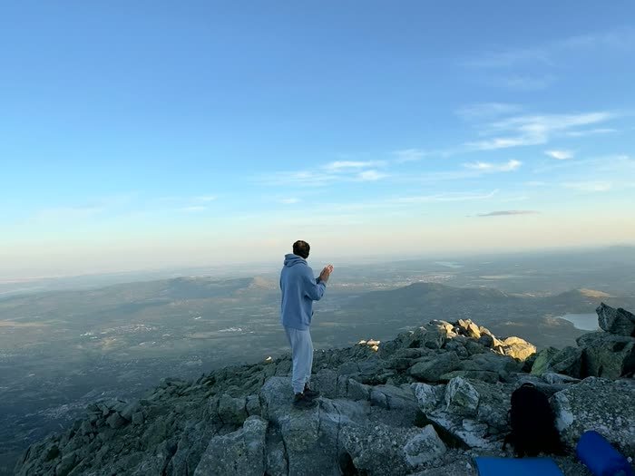 Alguien de pie en la cima con la primera luz