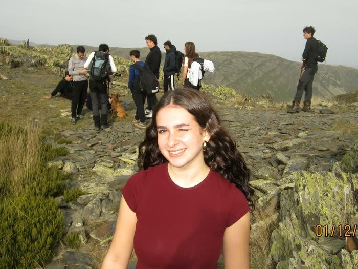 Una chica sonriendo en la ruta, con el grupo detrás