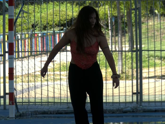 Una chica patinando a contraluz en una pista al aire libre