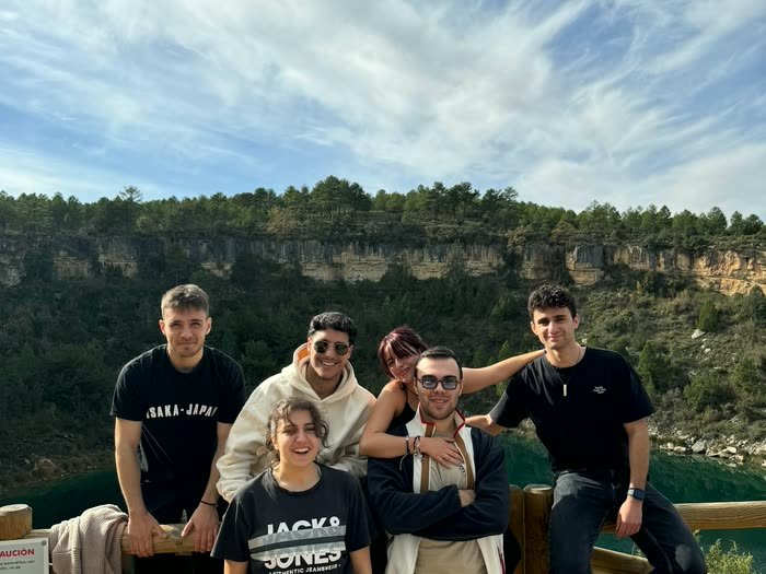 El grupo apoyado en una barandilla frente a una laguna verde