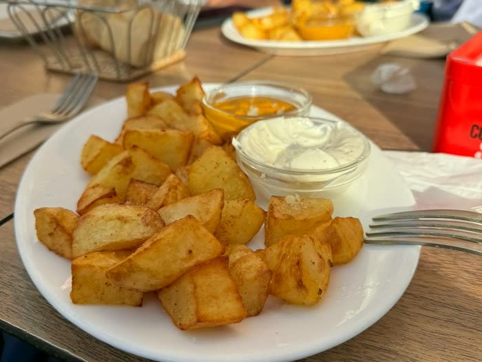 Un plato de patatas bravas en la mesa