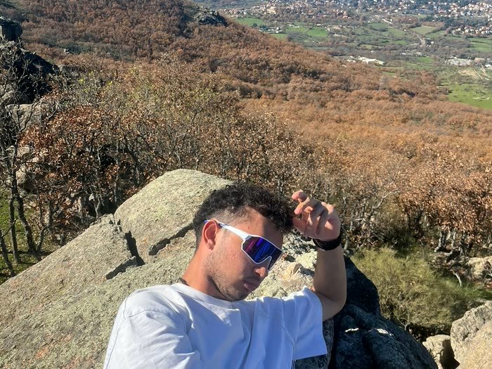 Alguien sentado en una roca mirando las montañas