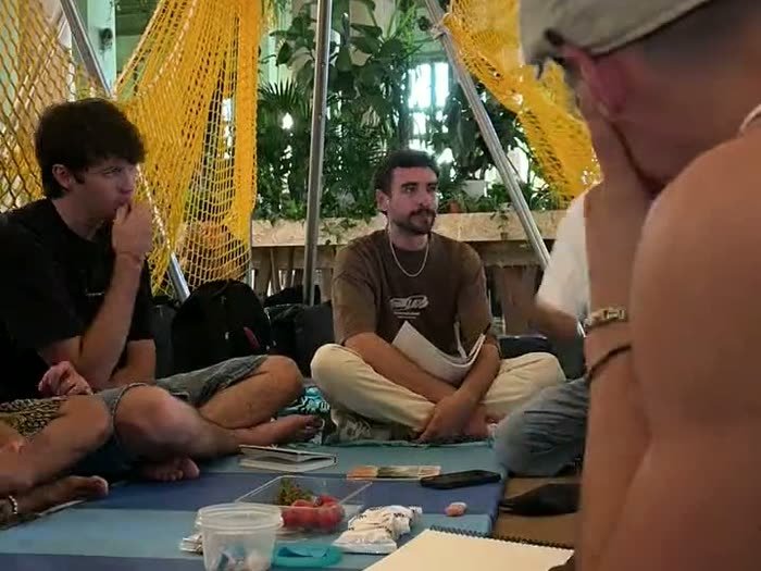 El primer taller: gente sentada en esterillas bajo redes colgadas