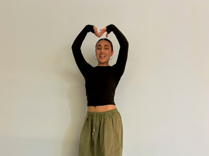 Una chica posando con las manos en corazón para que la dibujen