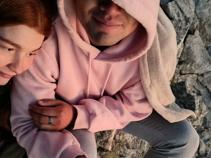 Dos personas abrazadas entre las rocas de la cima