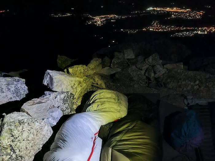 Los sacos de dormir en la cima con las luces de Madrid al fondo